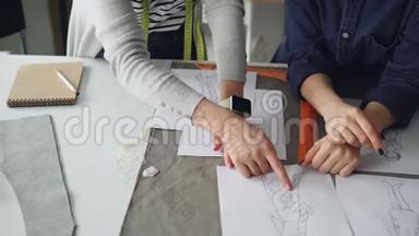 裁缝的特写镜头`双手在缝纫台上画草图。 女人们正在讨论<strong>服装</strong>设计。 <strong>创意创意</strong>